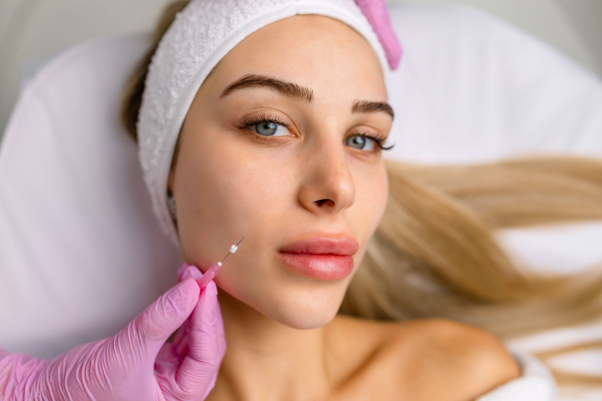 A woman is getting a botox injection in her face.