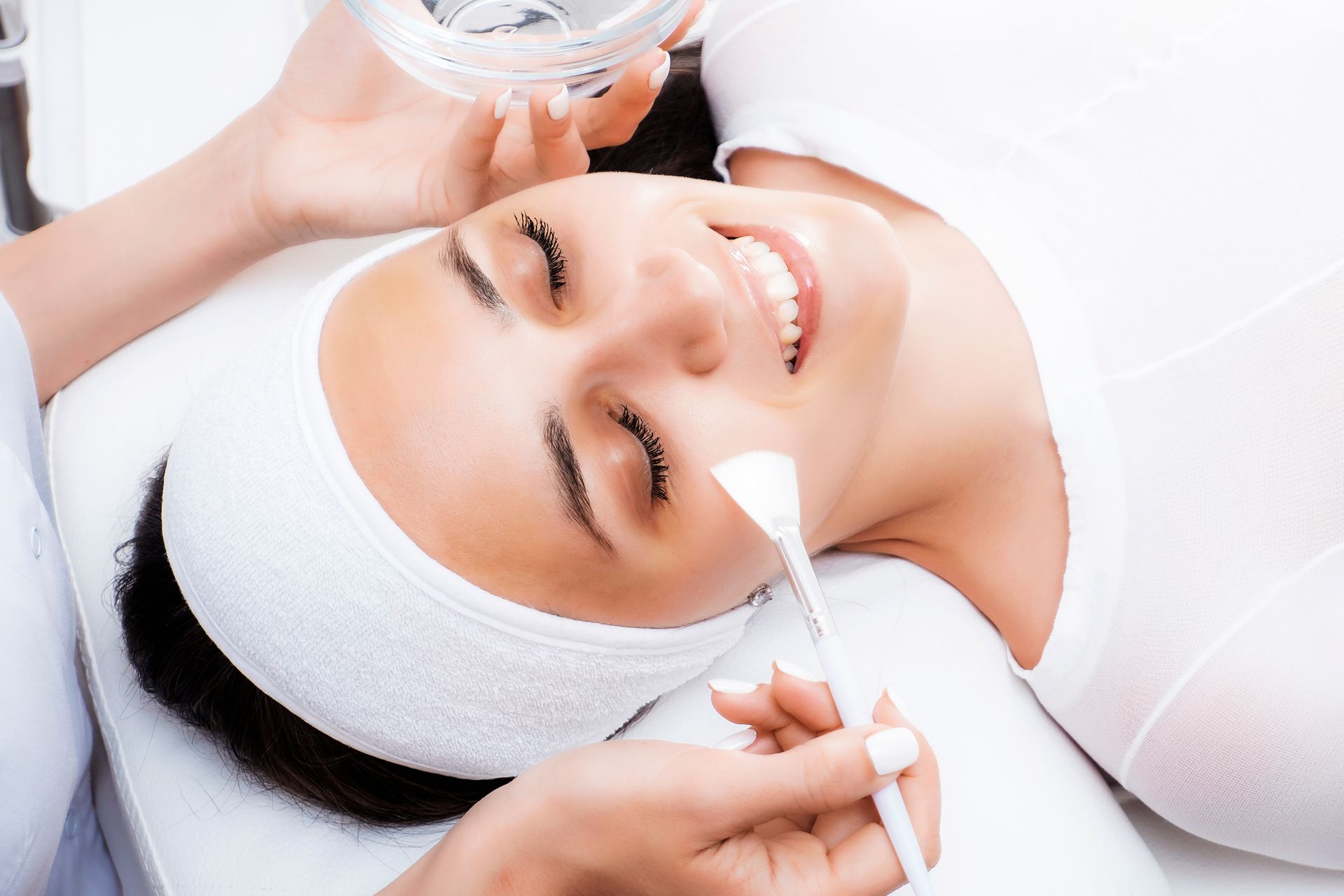 A woman is getting a facial treatment at a beauty salon.