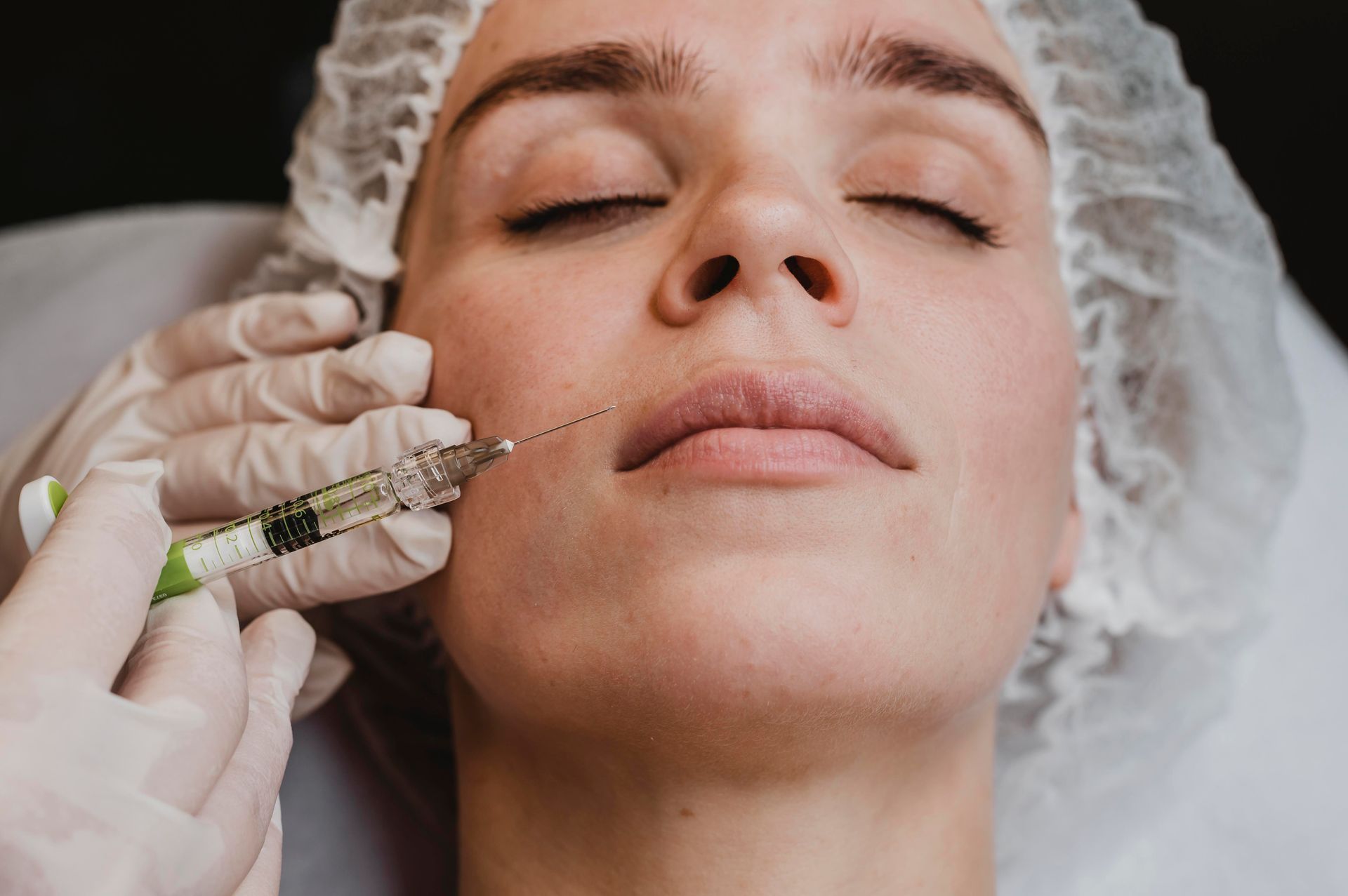 A woman is getting a botox injection in her face.