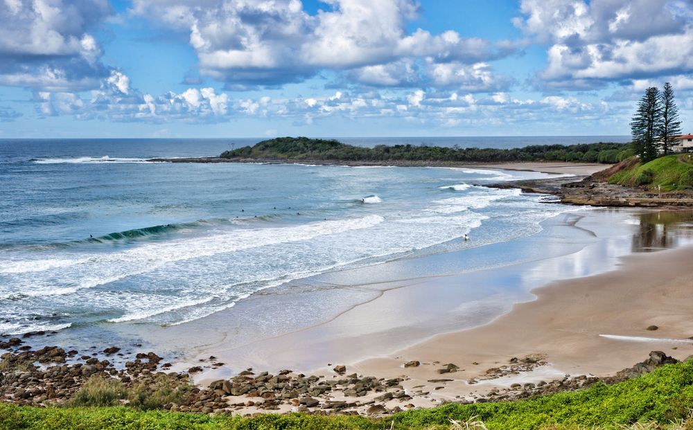 A Beach With Waves Crashing On The Shore On A Sunny Day — Yamba Pools & Spas In Yamba, NSW