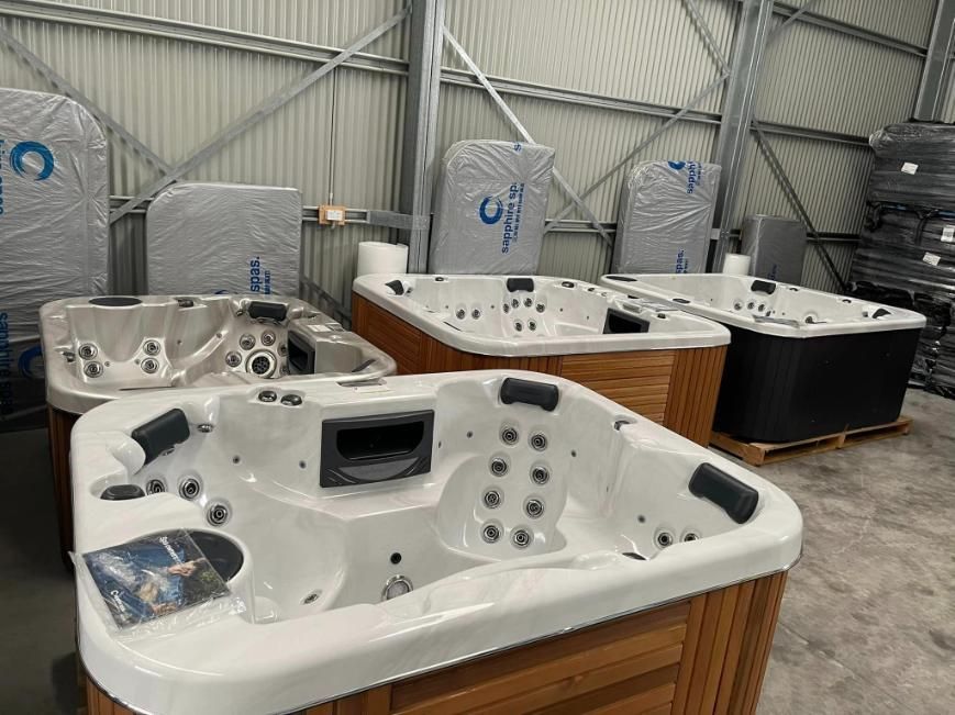 A Bunch Of Hot Tubs Are Sitting In A Warehouse — Yamba Pools & Spas In Yamba, NSW