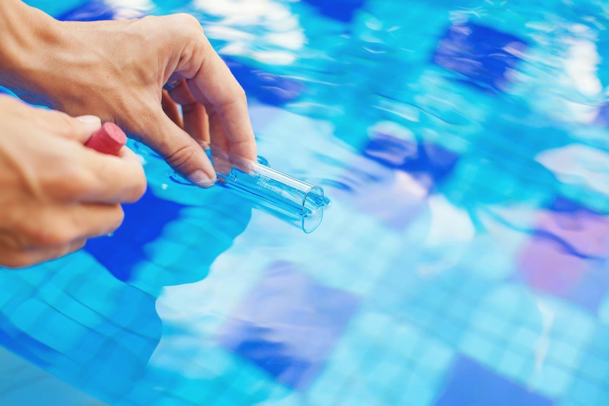 A Person Is filling A Test Kit Of A Swimming Pool — Yamba Pools & Spas In Yamba, NSW