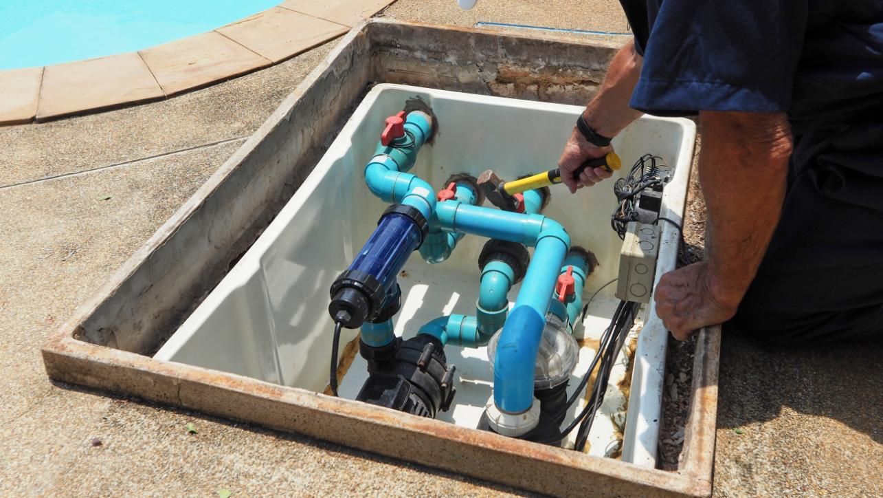 A Man Is Working On A Swimming Pool Pump — Yamba Pools & Spas In Yamba, NSW