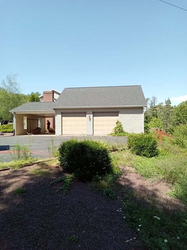 A house with a garage and a driveway in front of it.