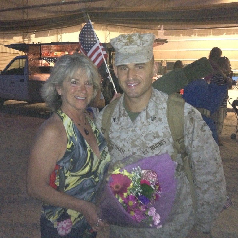 A man in a military uniform stands next to a woman holding flowers