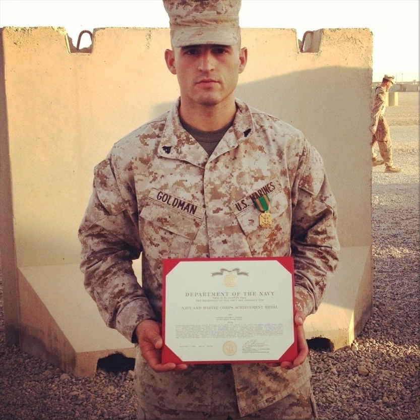 A man in a military uniform is holding a certificate