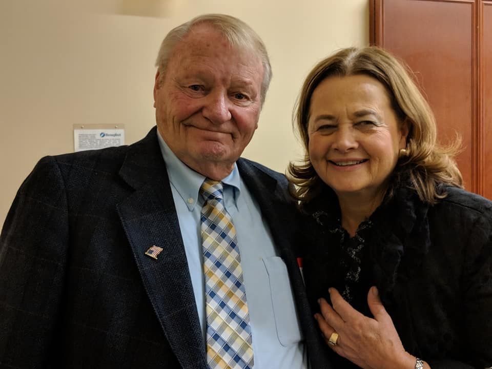 A man in a suit and tie is posing for a picture with a woman