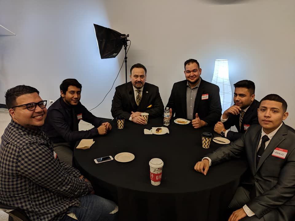 A group of men are sitting around a round table.