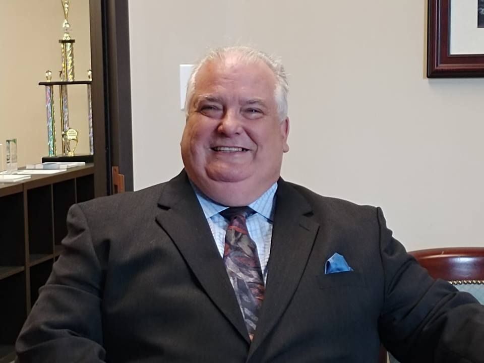 A man in a suit and tie is smiling for the camera