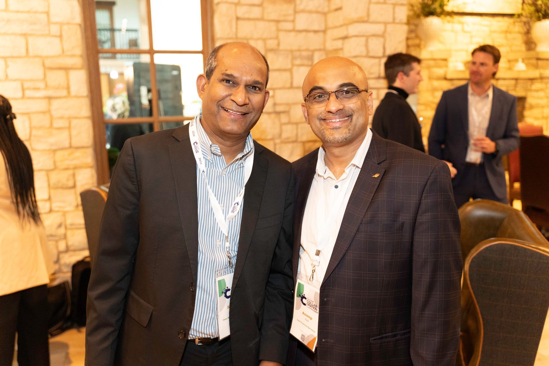 Two men in suits are posing for a picture in a room.