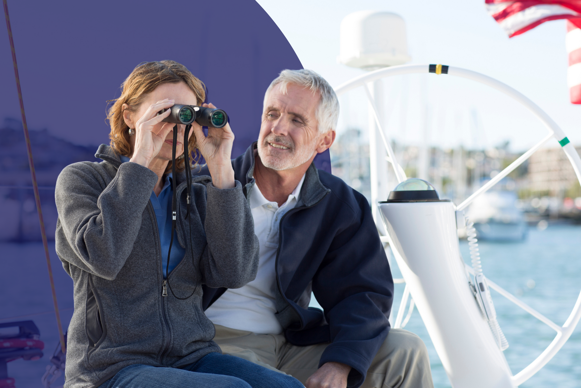 A man and a woman are sitting on a boat looking through binoculars.