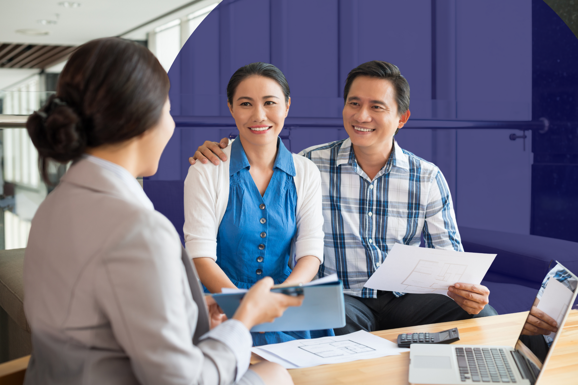 A man and woman are sitting at a table talking to a woman.