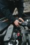 A man is working on the engine of a car.