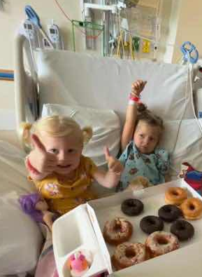 LBF hero Cameron and friend eating donuts in hospital bed