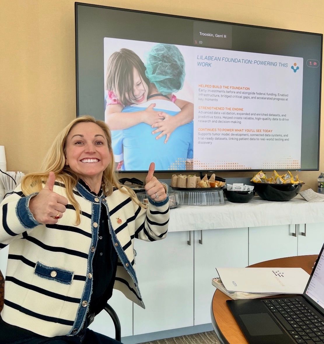 Stewie Corno giving a thumbs up in front of screen presentation