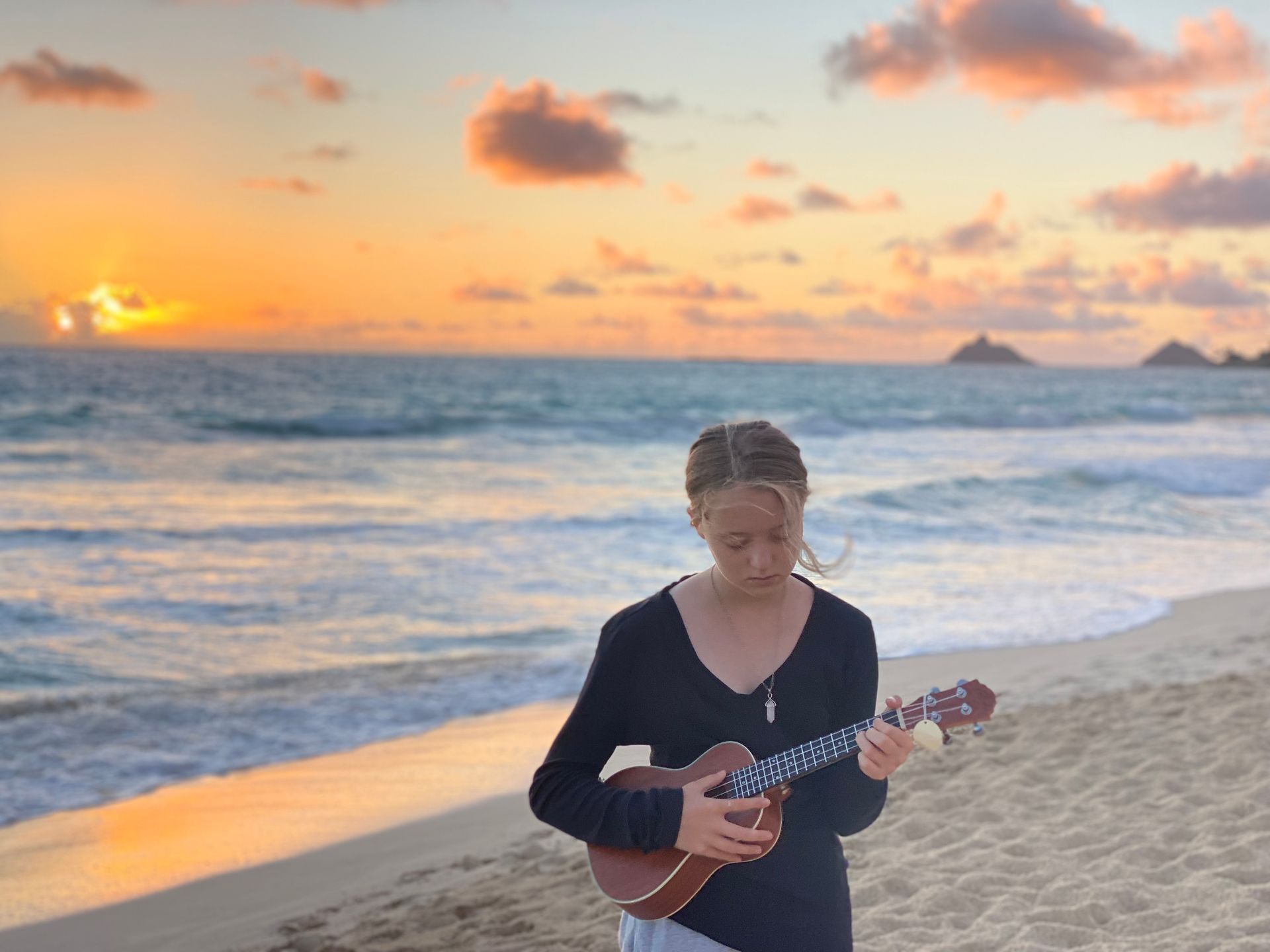 LBF Hero Zoe FitzGerald playing ukulele on the beach