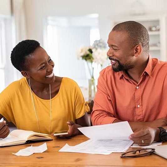 Man and Woman looking at paper and smiling.