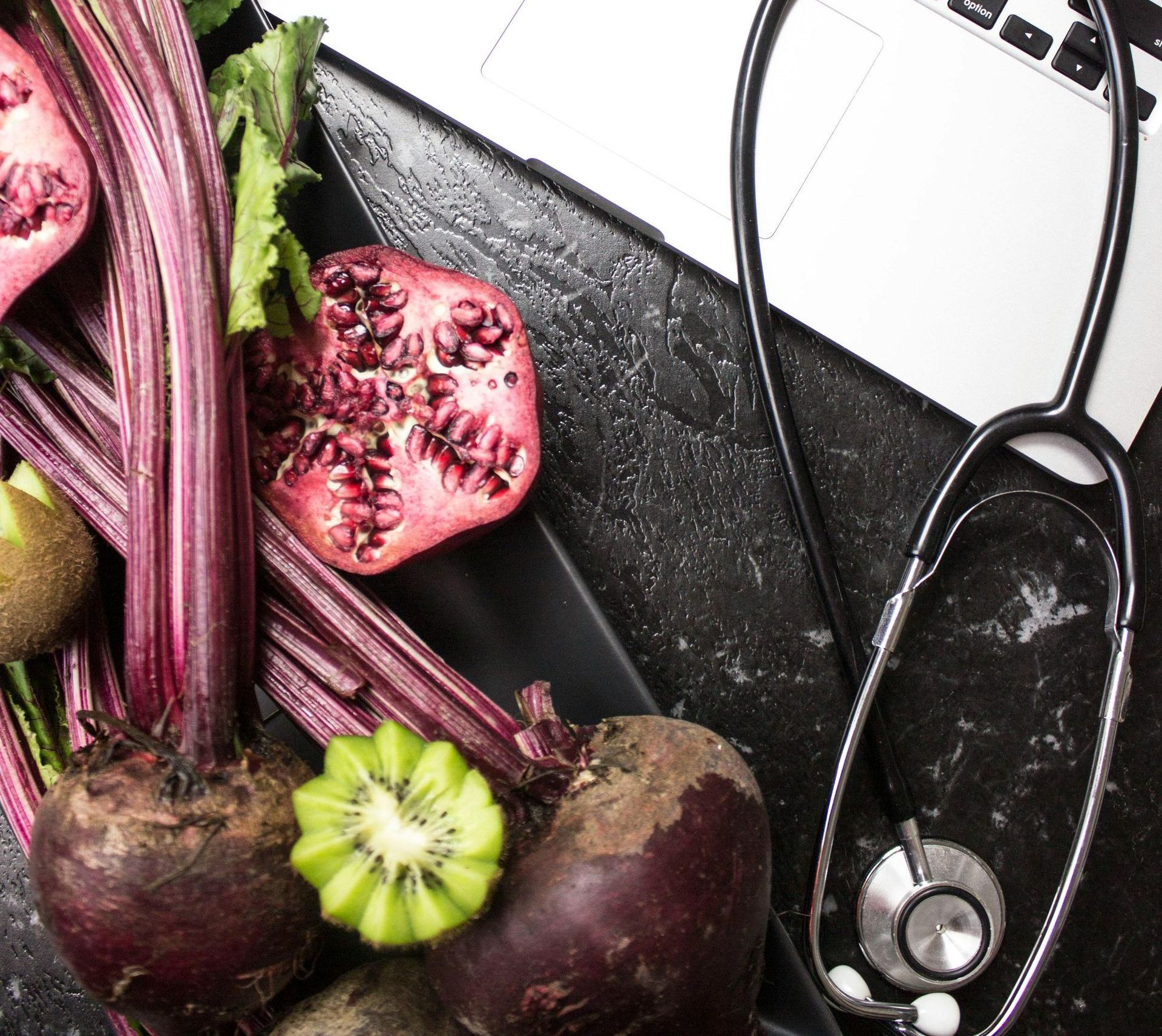A stethoscope is sitting on a table next to a laptop.