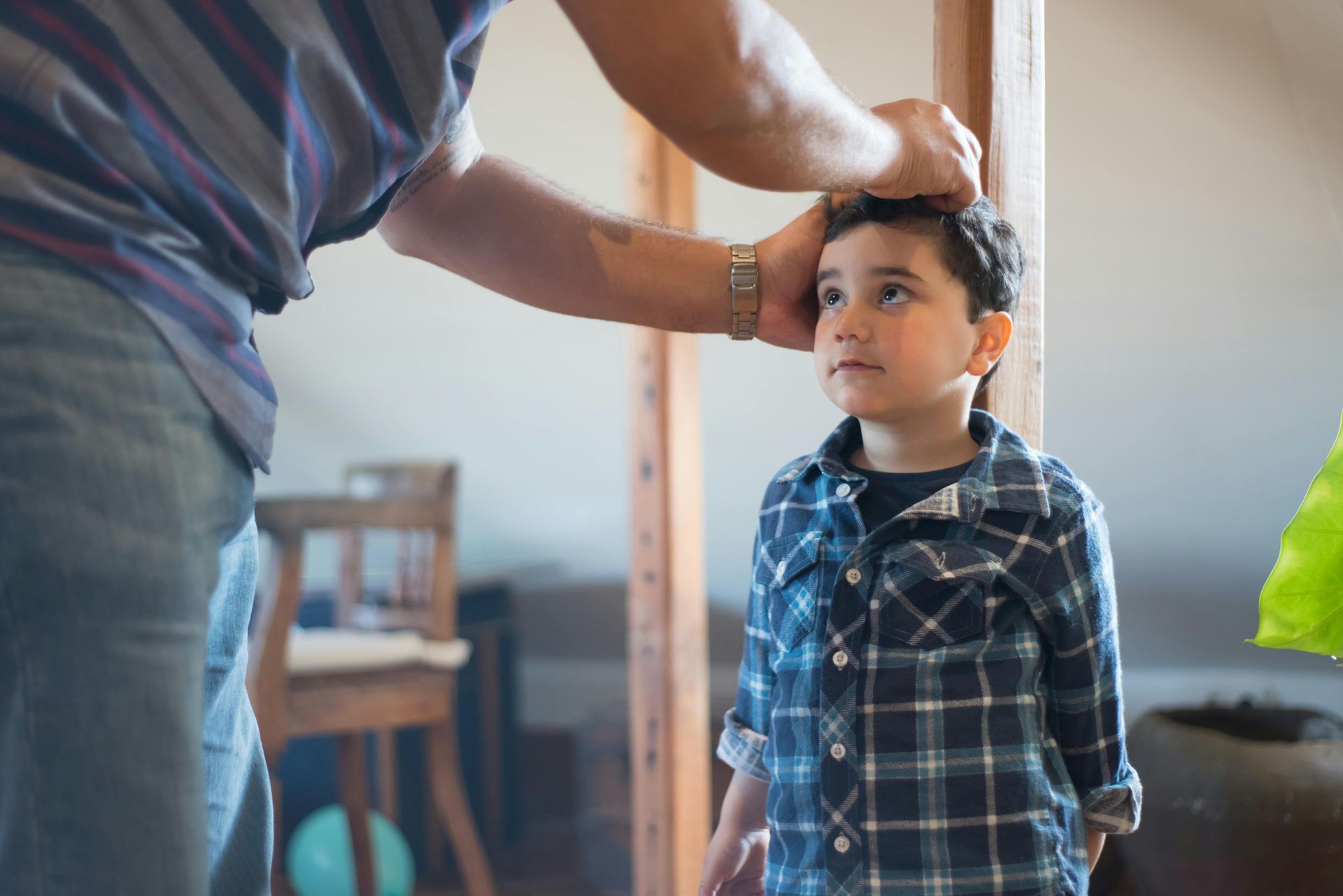 A man is measuring the height of a young boy.