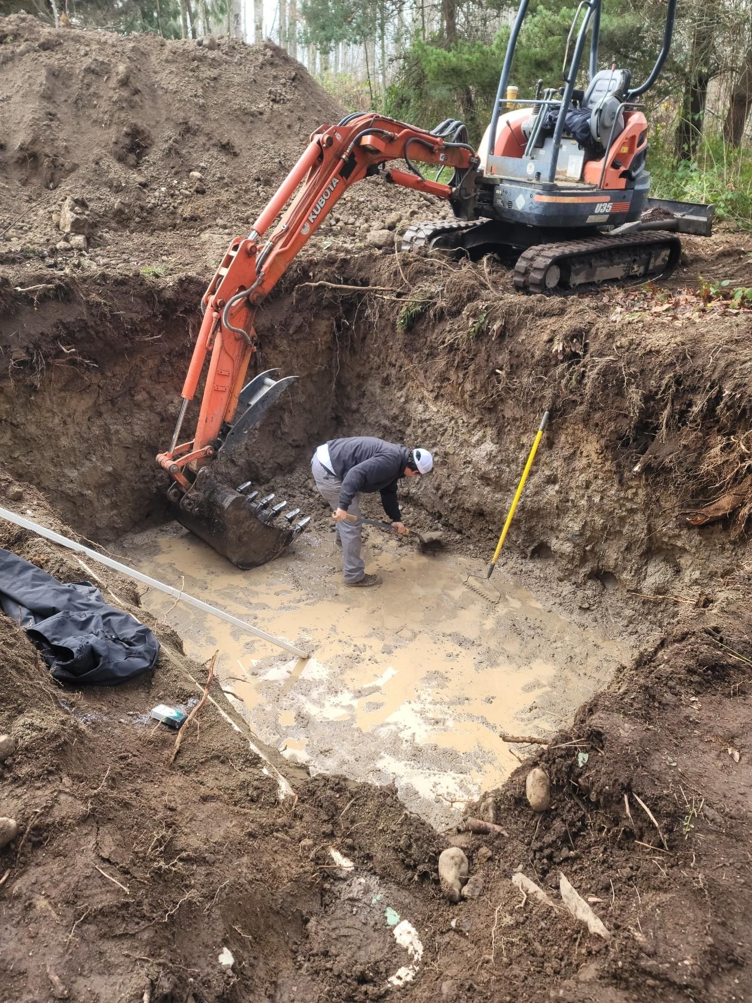 A man is digging a hole in the dirt with an excavator.