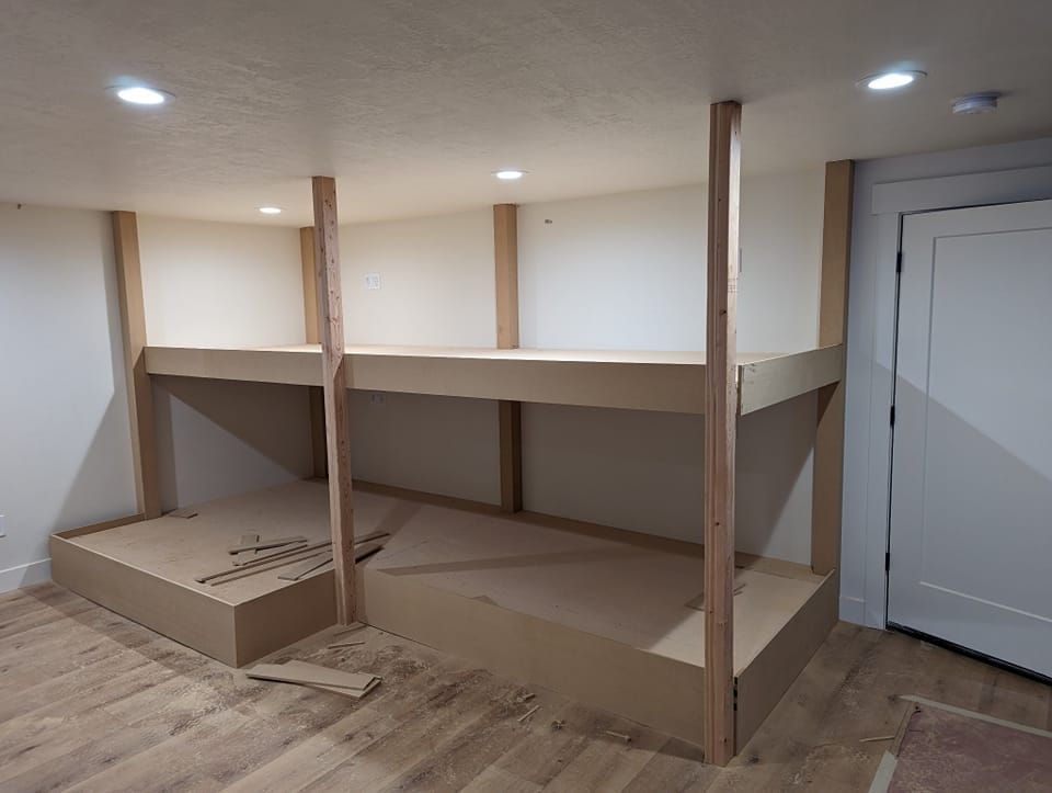 A wooden bunk bed is being built in a room.