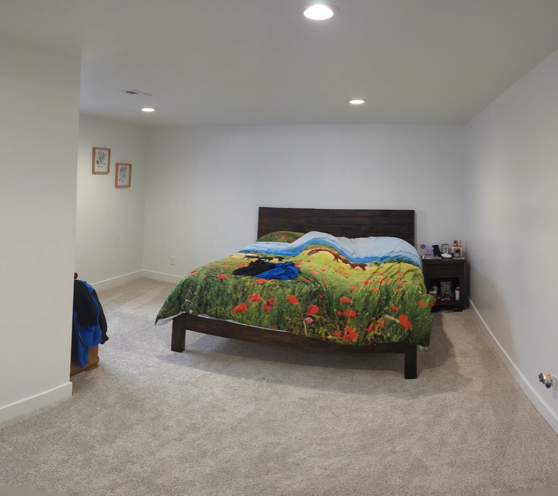 A bedroom with a large bed and a nightstand