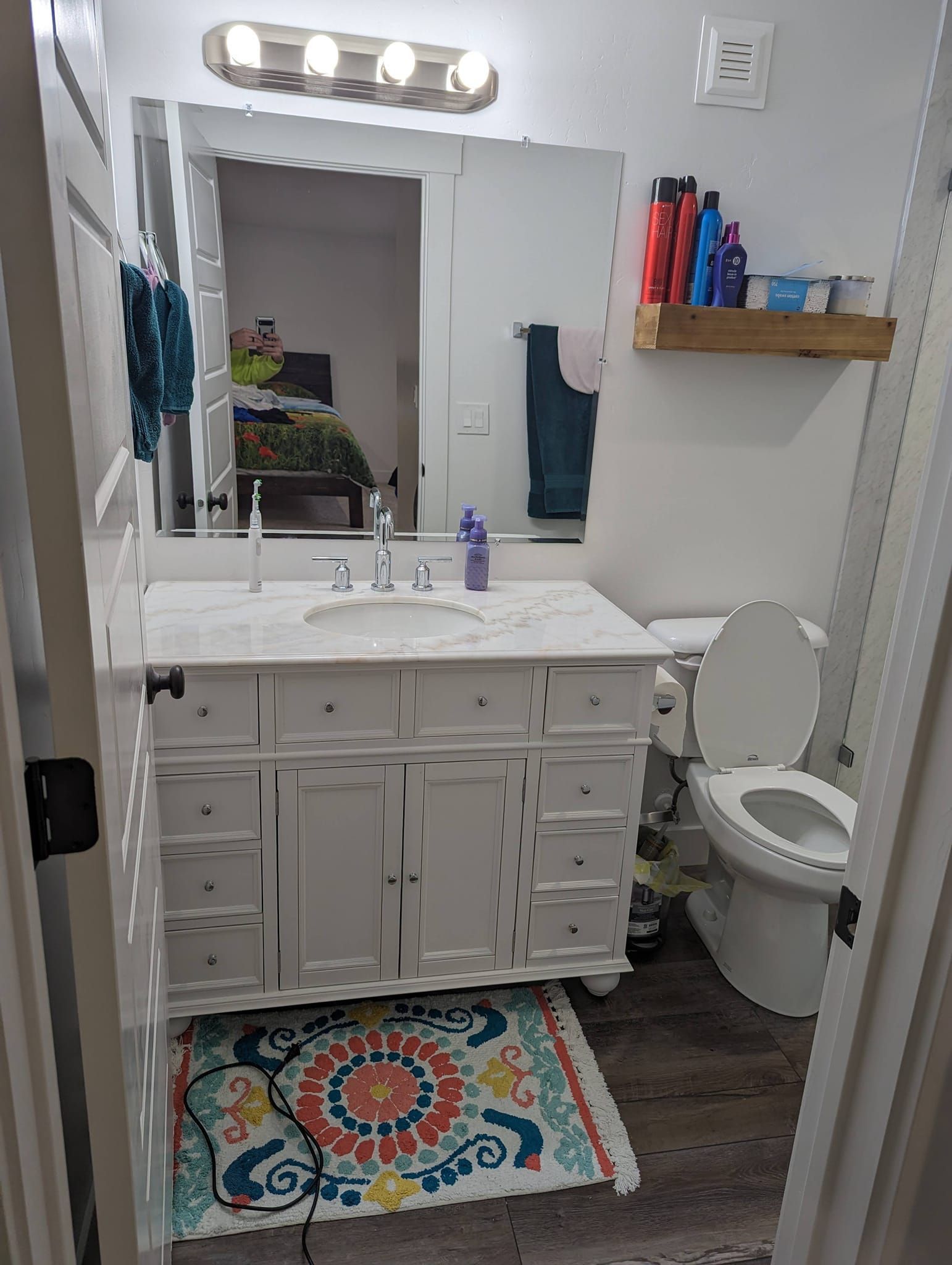 A bathroom with a sink , toilet and mirror.