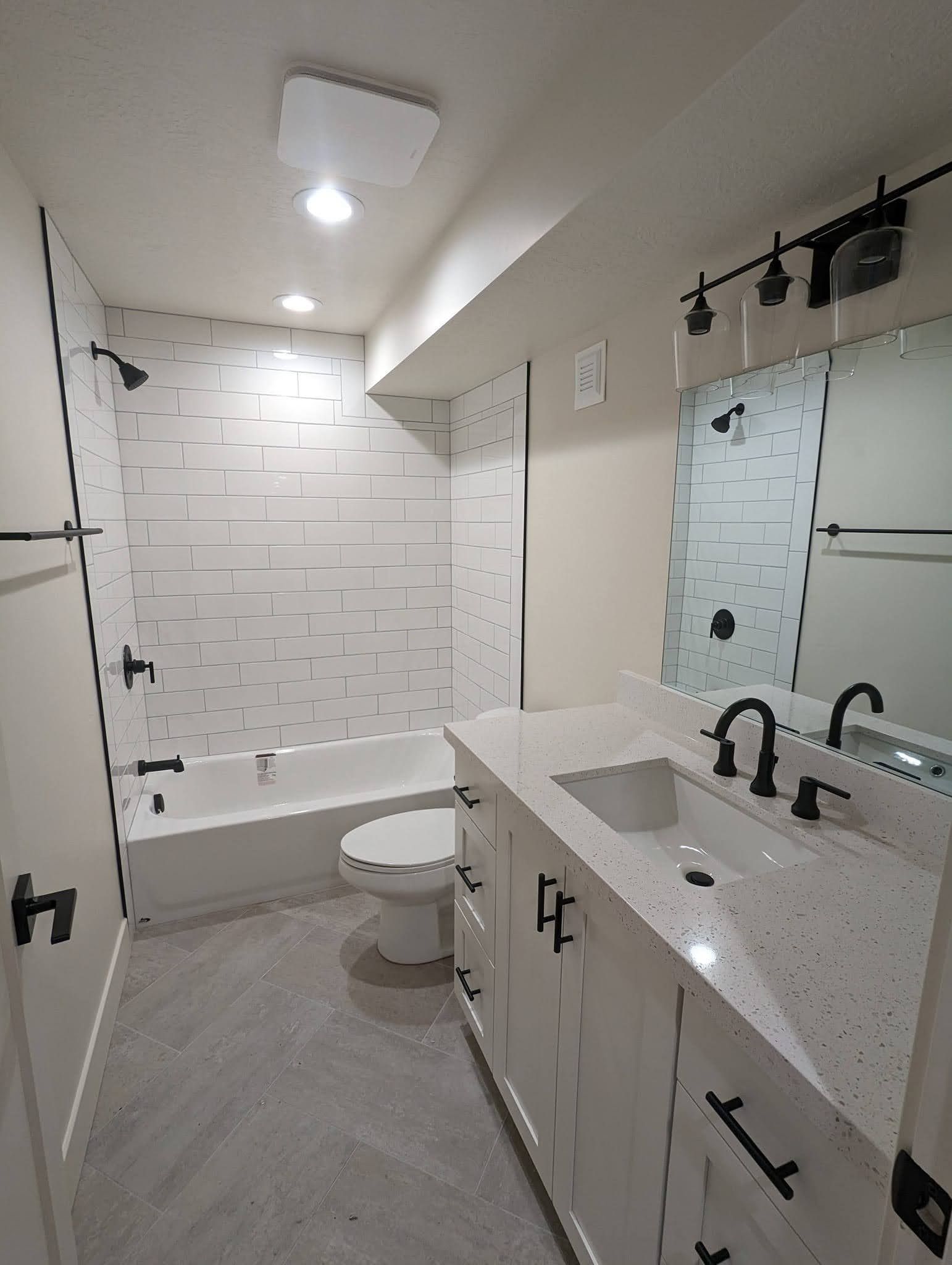 A bathroom with a sink , toilet , bathtub and mirror.