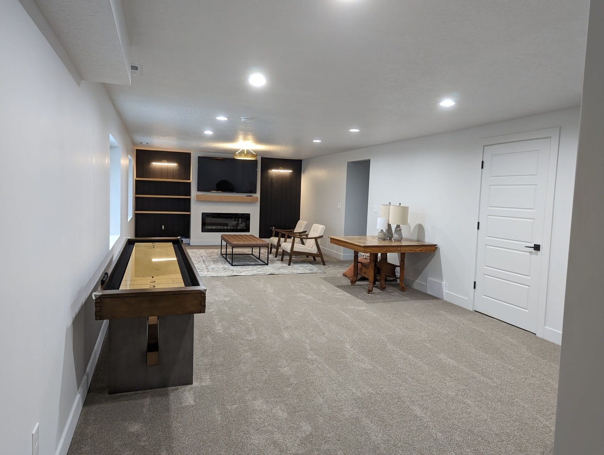 There is a shuffleboard table in the middle of the room.