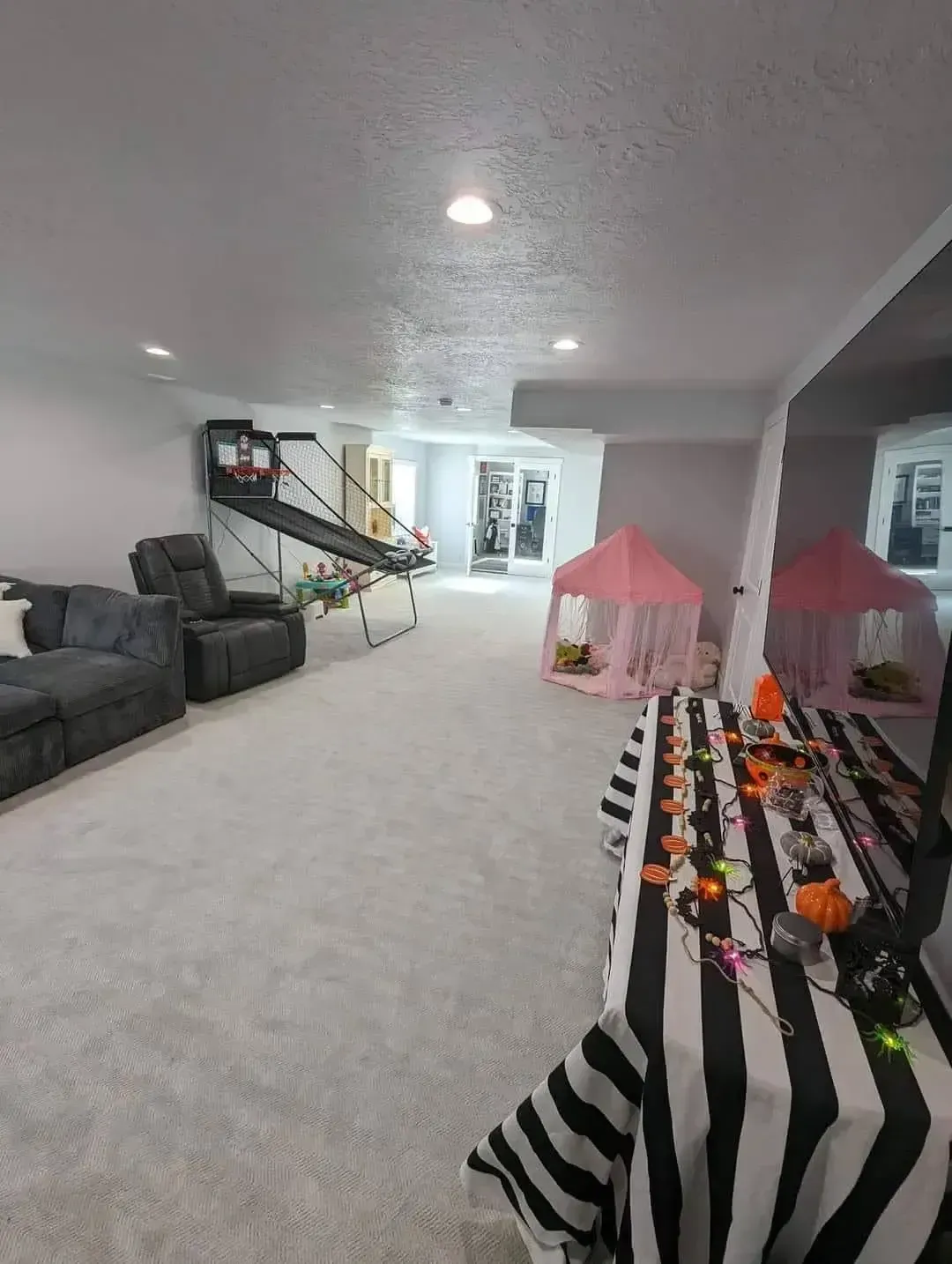 There is a table with a black and white striped tablecloth in the middle of the room.
