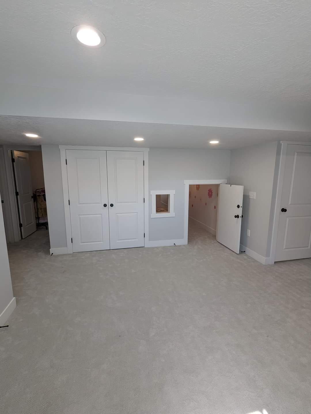 There is a playhouse in the corner of the room.