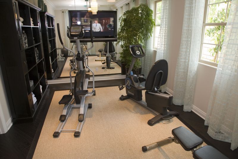 A home gym with a treadmill and exercise bikes