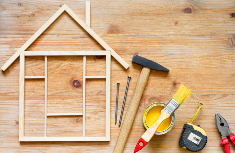 A wooden house with tools on a wooden table.