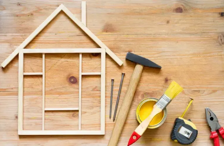 A wooden house with tools on a wooden table.