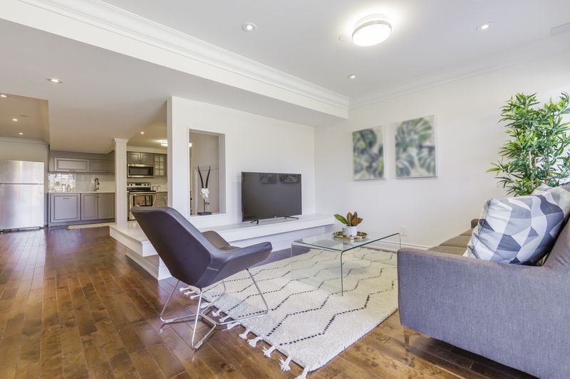 A living room with a couch , chair , coffee table and television.