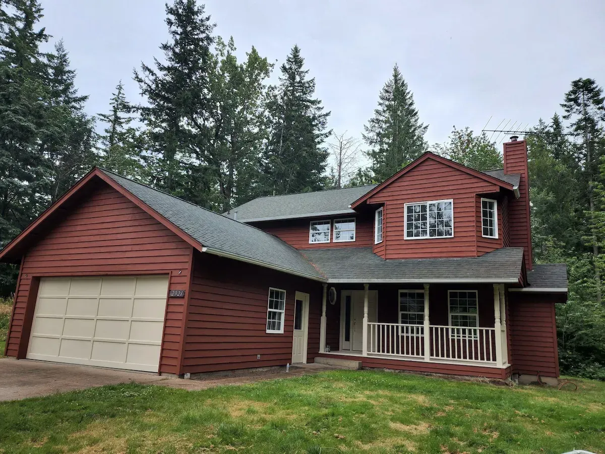 A newly painted red house with a garage