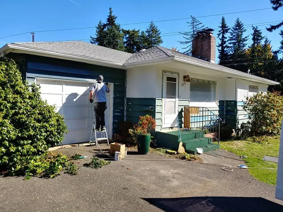 A painting contractor painting a house in Bellingham, WA 