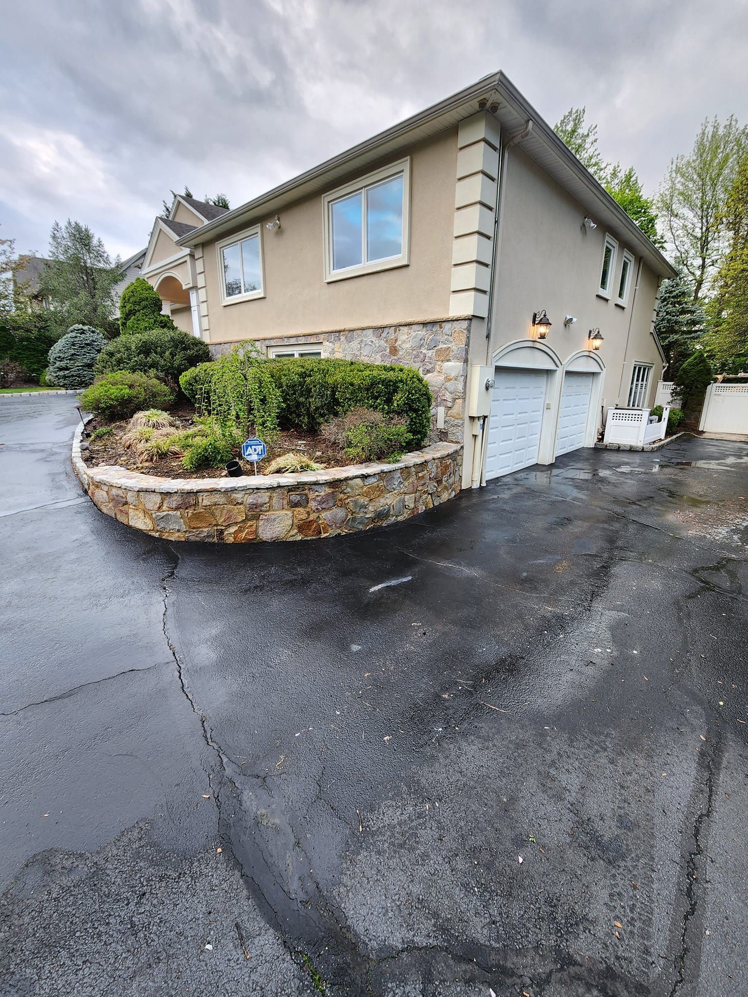 A person is cleaning a patio with a hose.