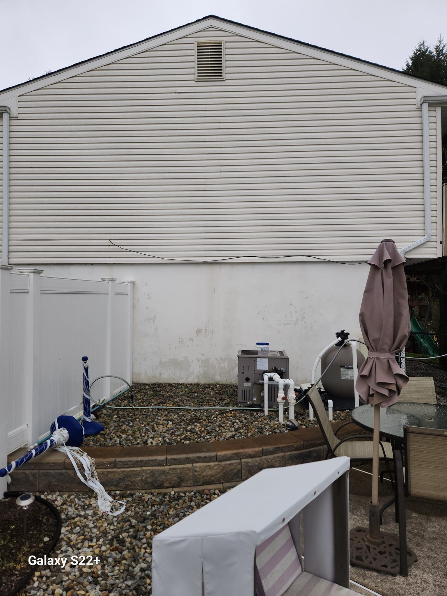 A white house with a fence and umbrella in front of it
