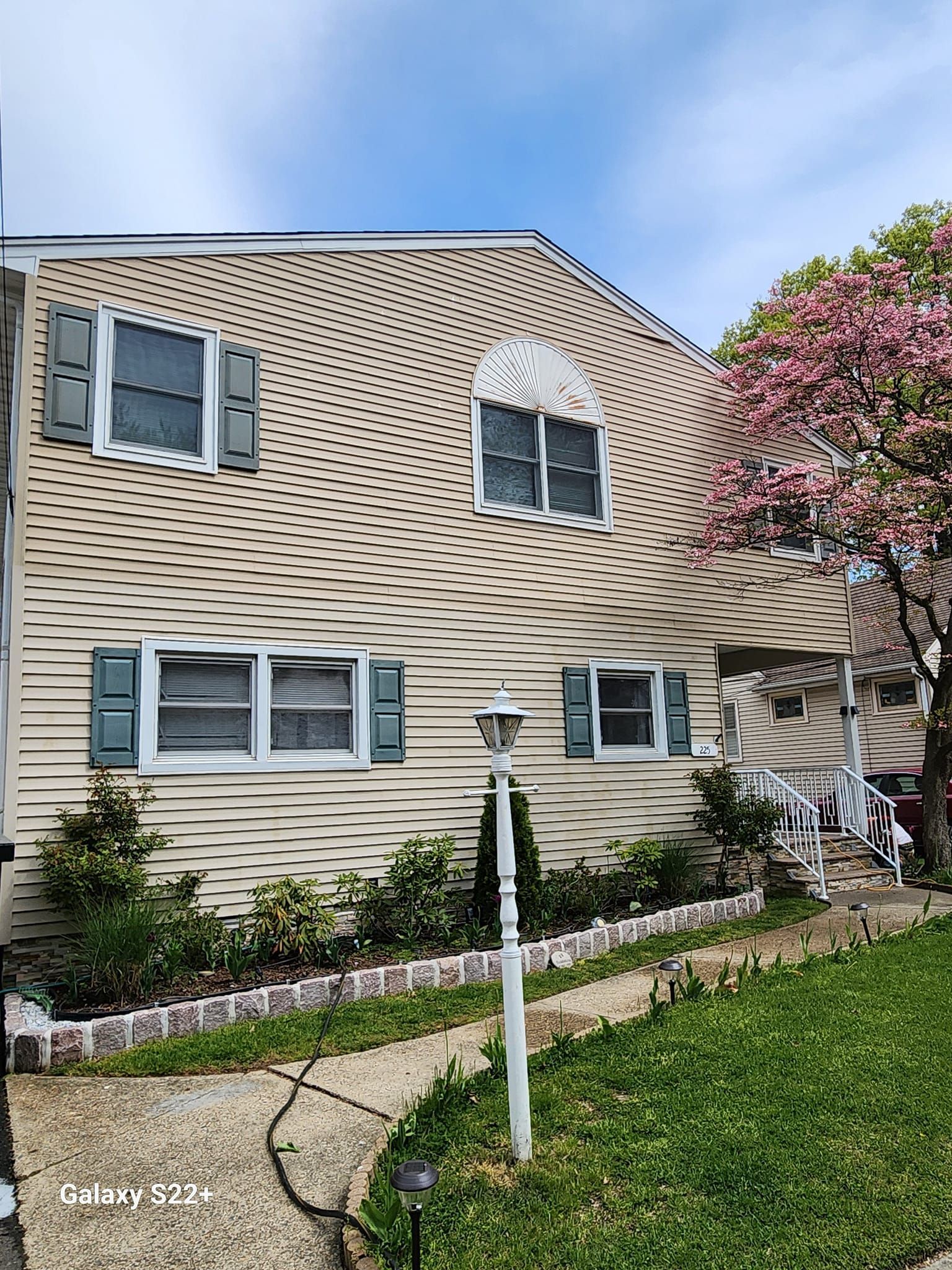 A house with a curved roof and a tree in front of it.