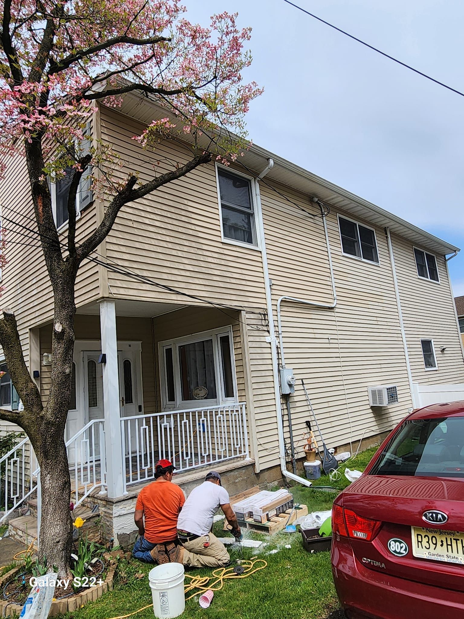 A group of men are painting the side of a house.