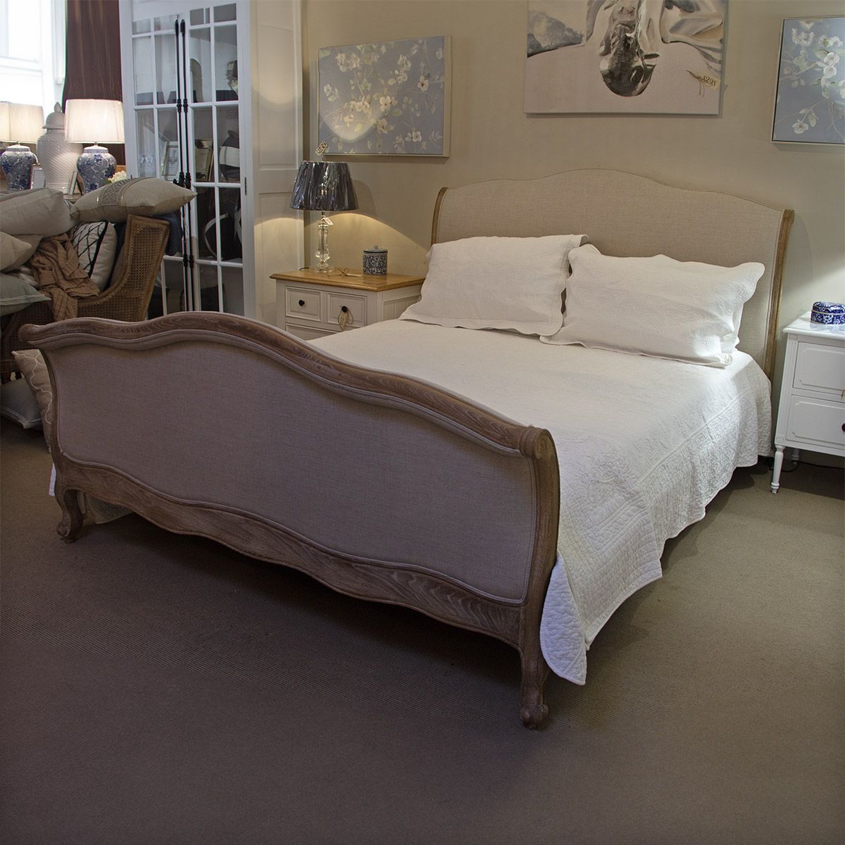 A bed with fabric panels, timber trimmings and legs