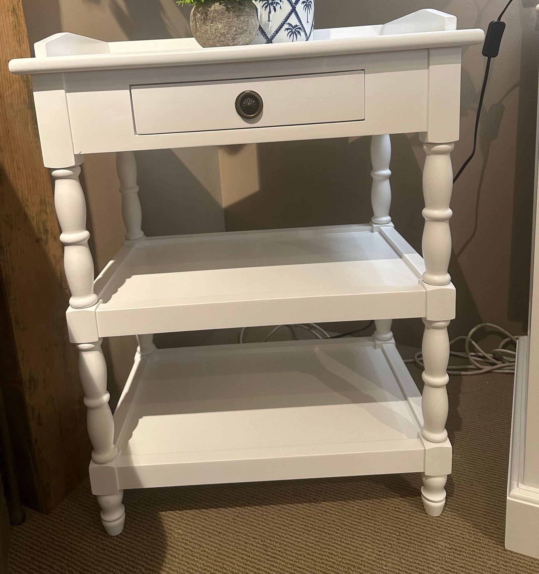 A white painted rectangular side table with one small drawer and two shelves below.