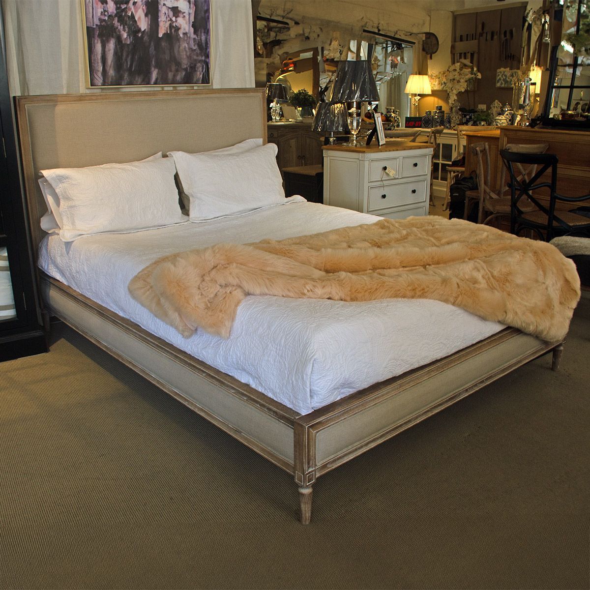 A bed with fabric panels, timber trimmings and legs