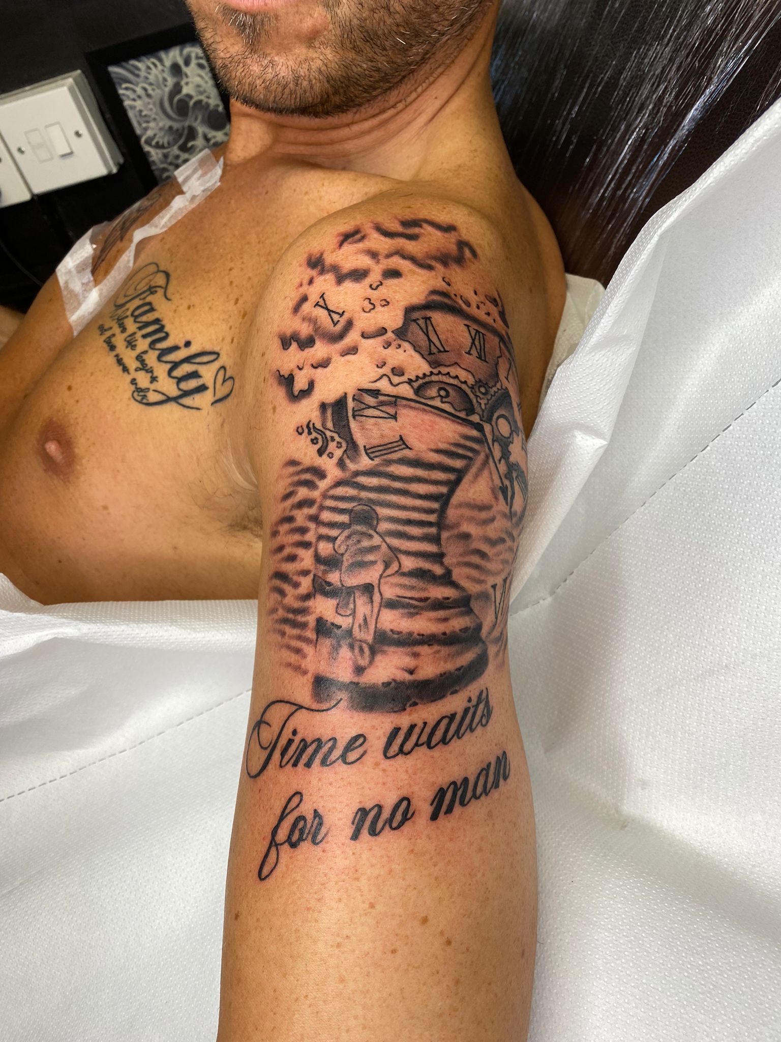 A man has a tattoo on his arm that says `` time waits for no man ''.