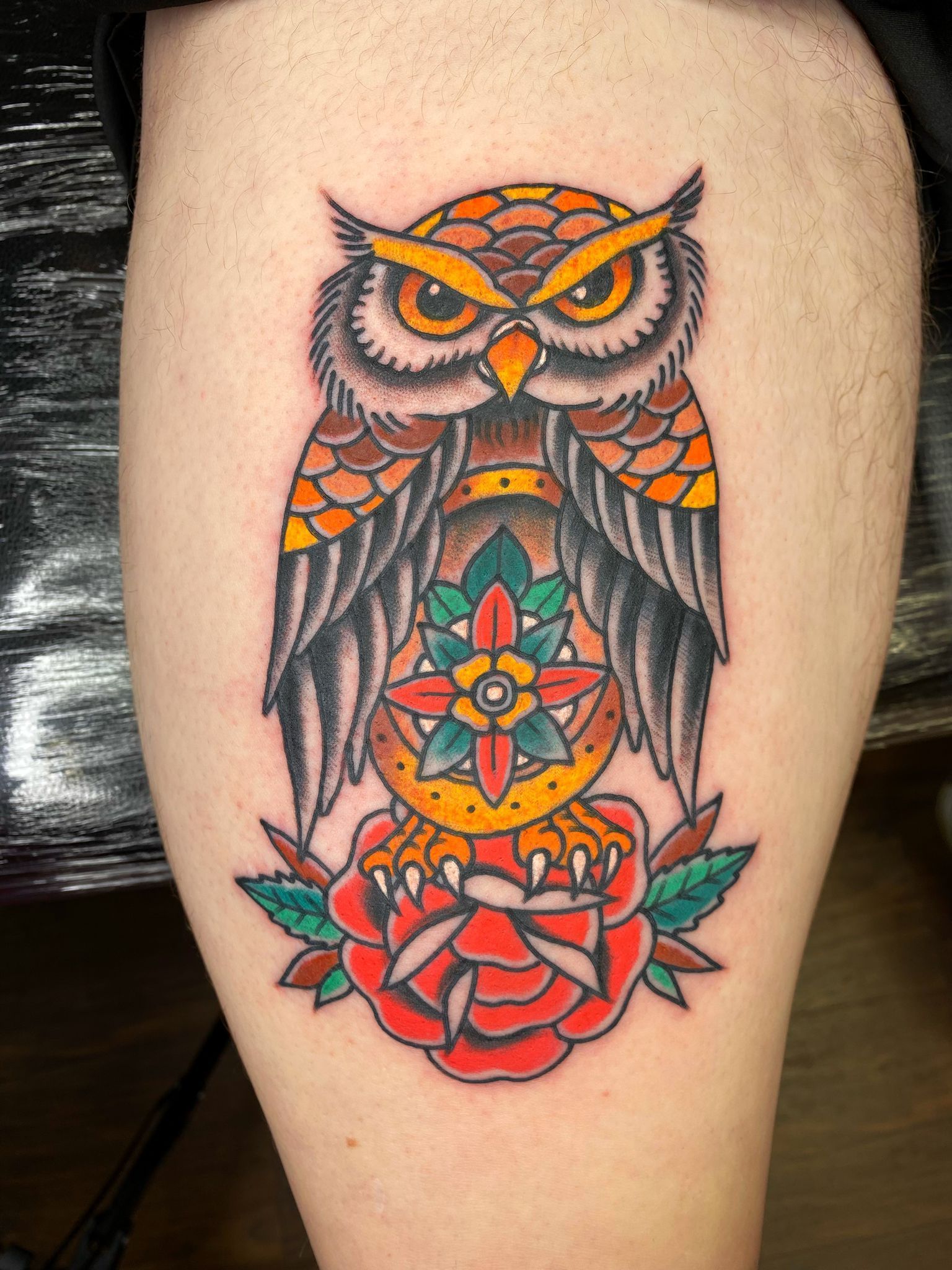 A person has a tattoo of an owl on their leg