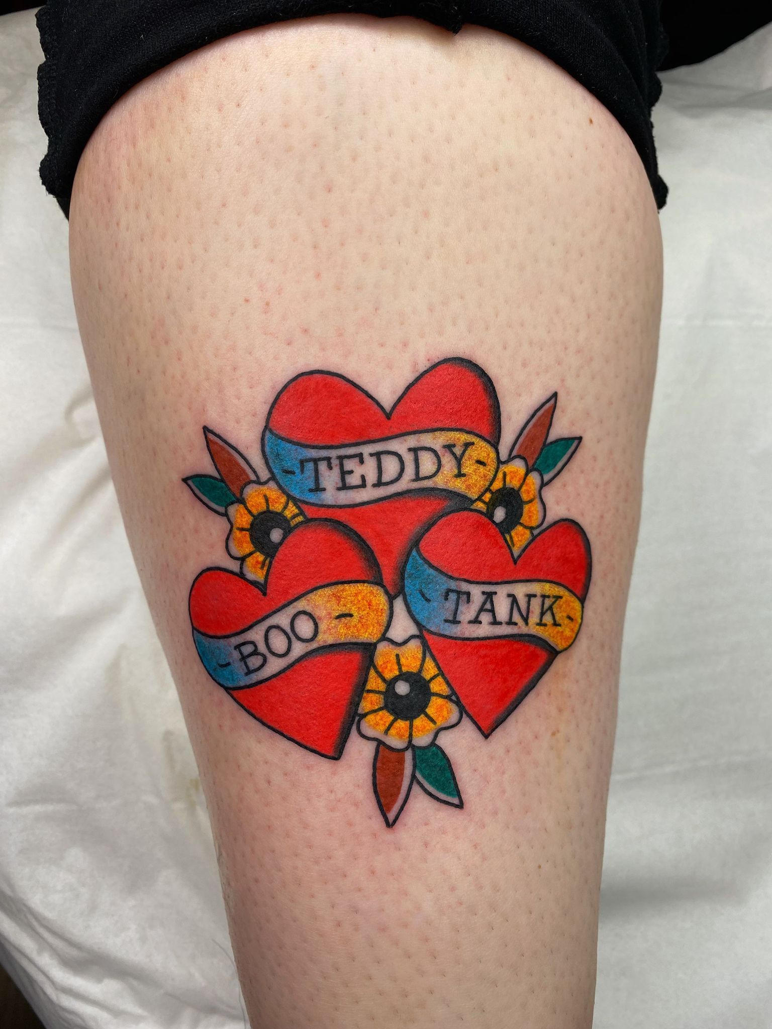 A tattoo on a person 's leg that says teddy boo tank