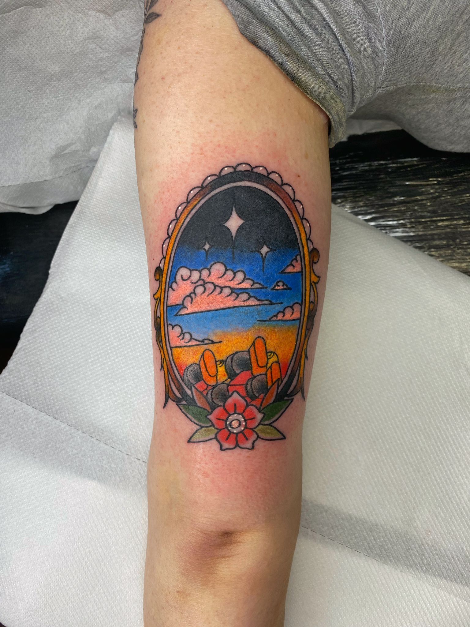 A tattoo of a landscape in a mirror on a person 's arm.
