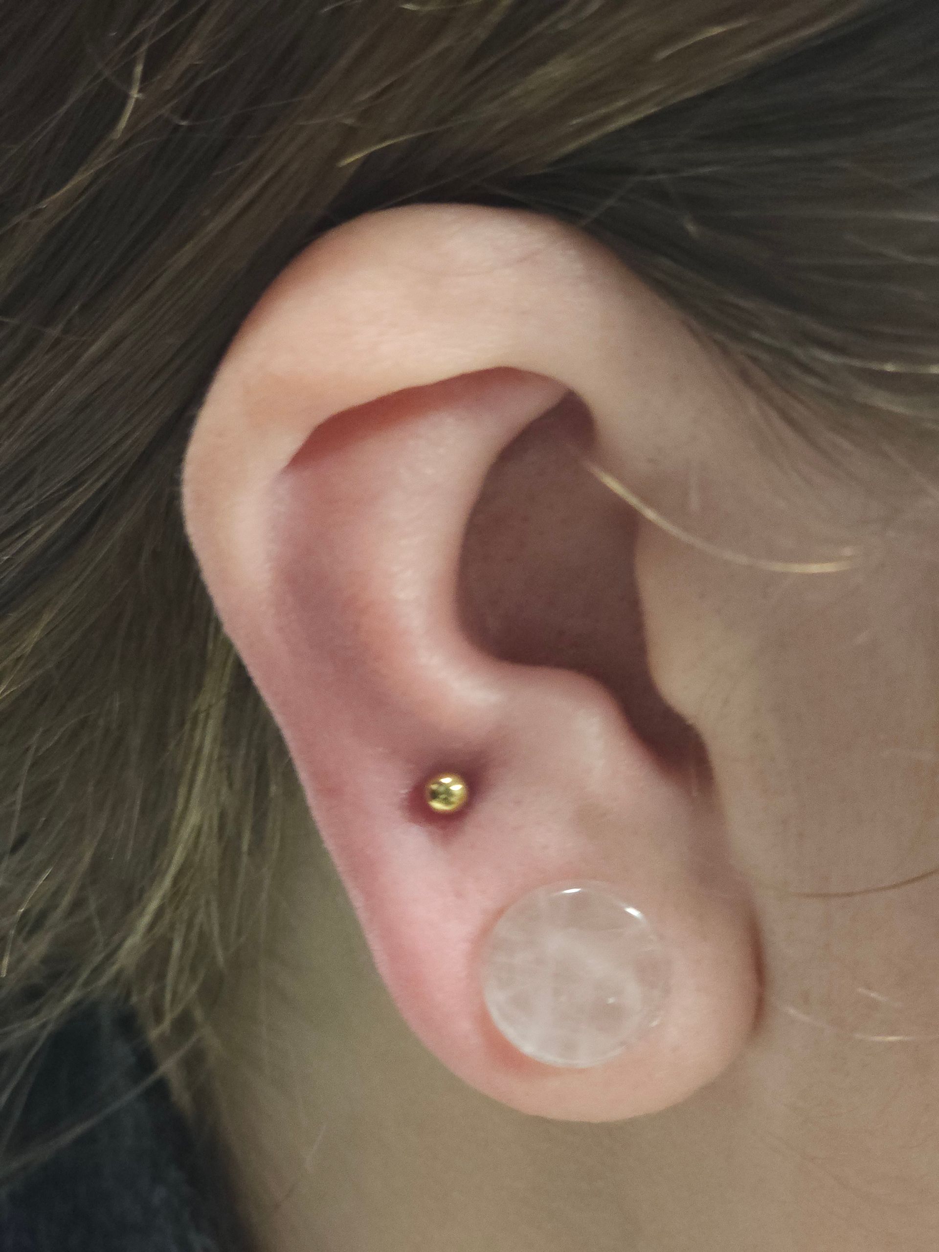 A close up of a person 's ear with earrings