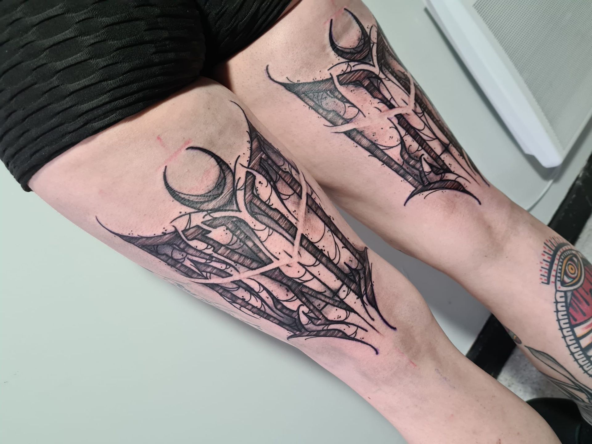 A woman has two tattoos on her legs.